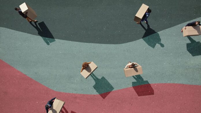 Businesspeople carrying boxes around on painted lanes on asphalt